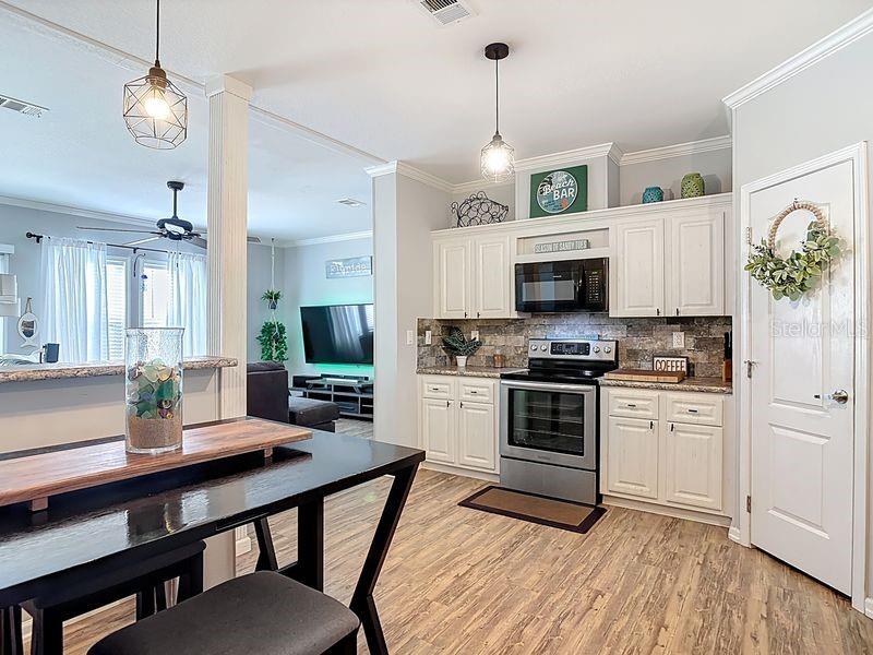 102 Ash Street Edgewater, FL 32141 - Photo 7 of 36 a kitchen with a chandelier stainless steel appliances and dining table