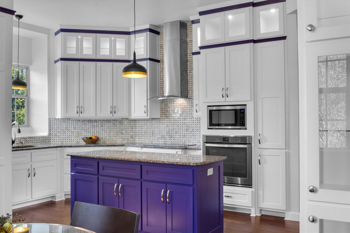 a kitchen with a sink a stove cabinets and a wooden floor
