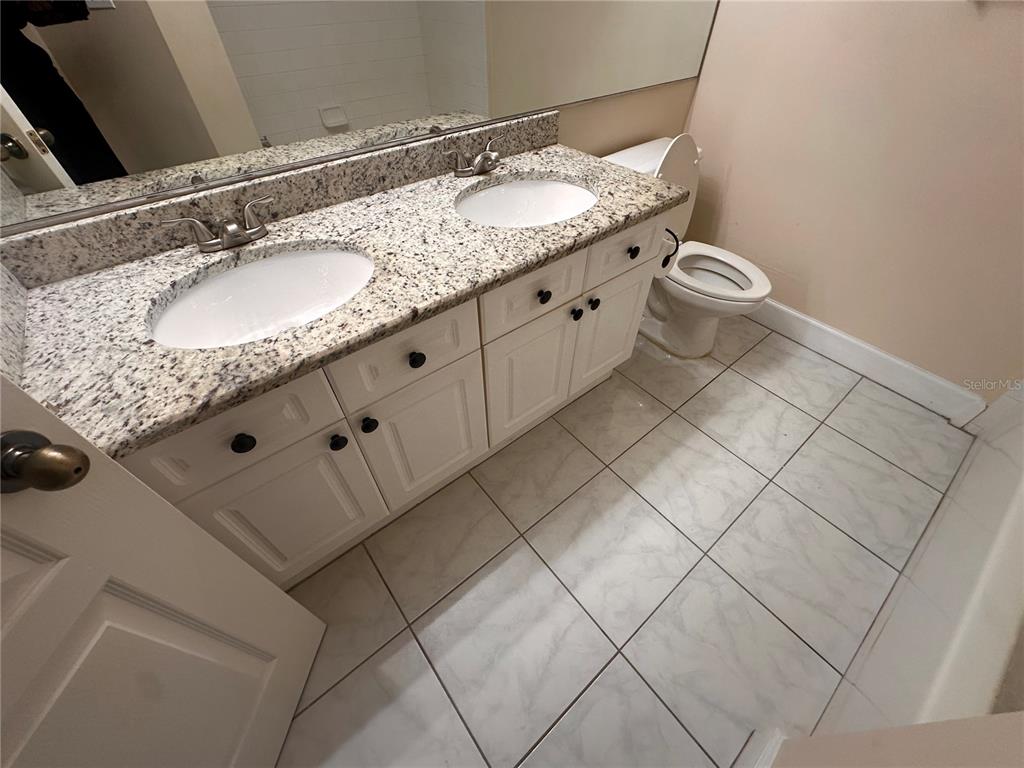 709 Bloom Street, Unit 240 Celebration, FL 34747 - Photo 13 of 17 a bathroom with a granite countertop sink and a mirror