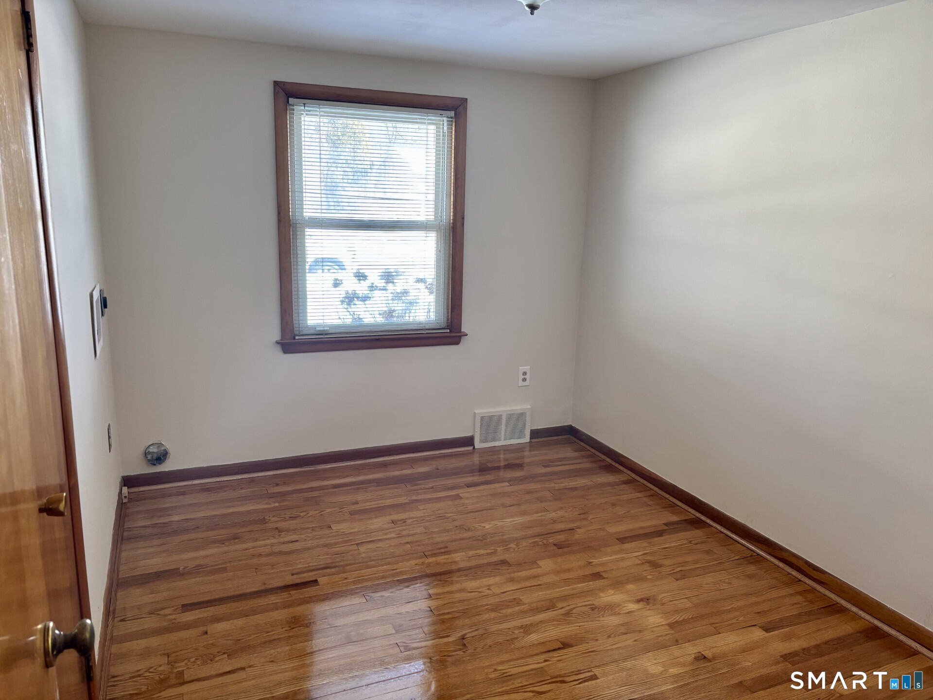 148 Edgewood Drive Torrington, CT 06790 - Photo 2 of 8 an empty room with wooden floor and windows