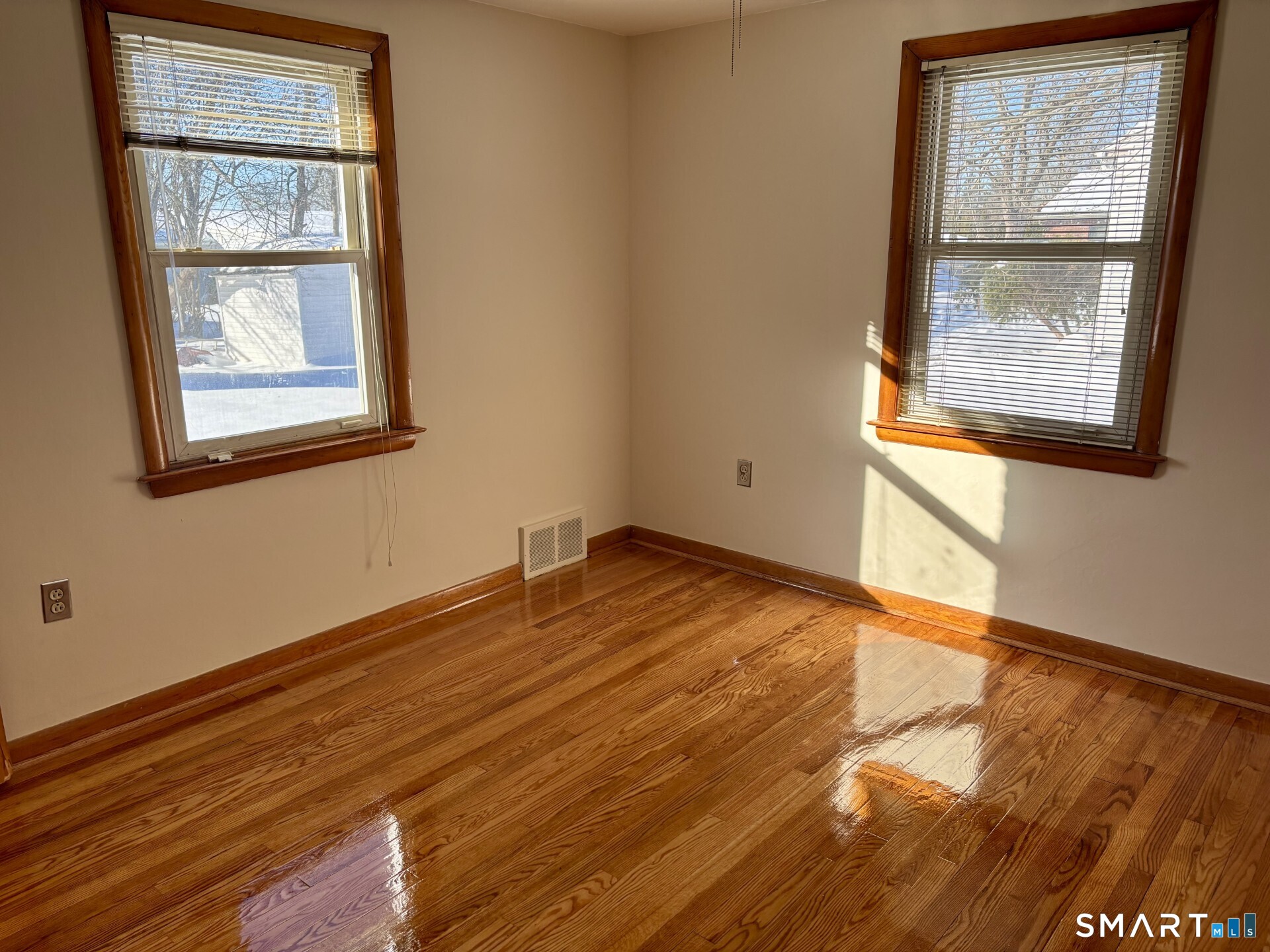 148 Edgewood Drive Torrington, CT 06790 - Photo 4 of 8 an empty room with wooden floor and windows