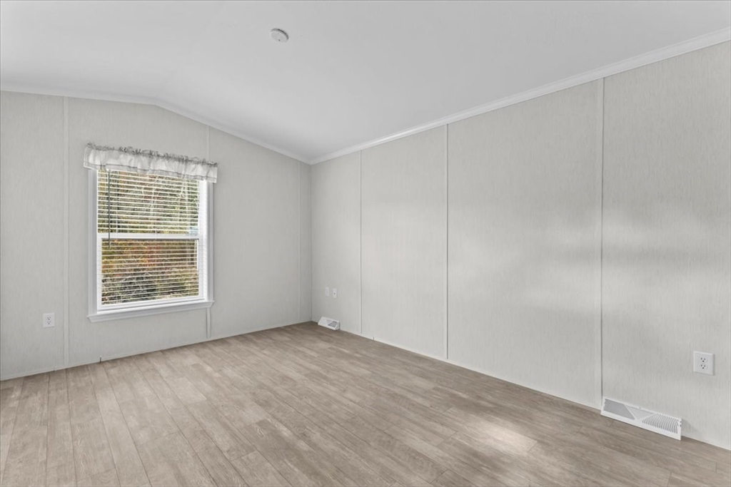 1540 Broadway, Unit 35 Raynham, MA 02767 - Photo 14 of 21 a view of an empty room with wooden floor and a window