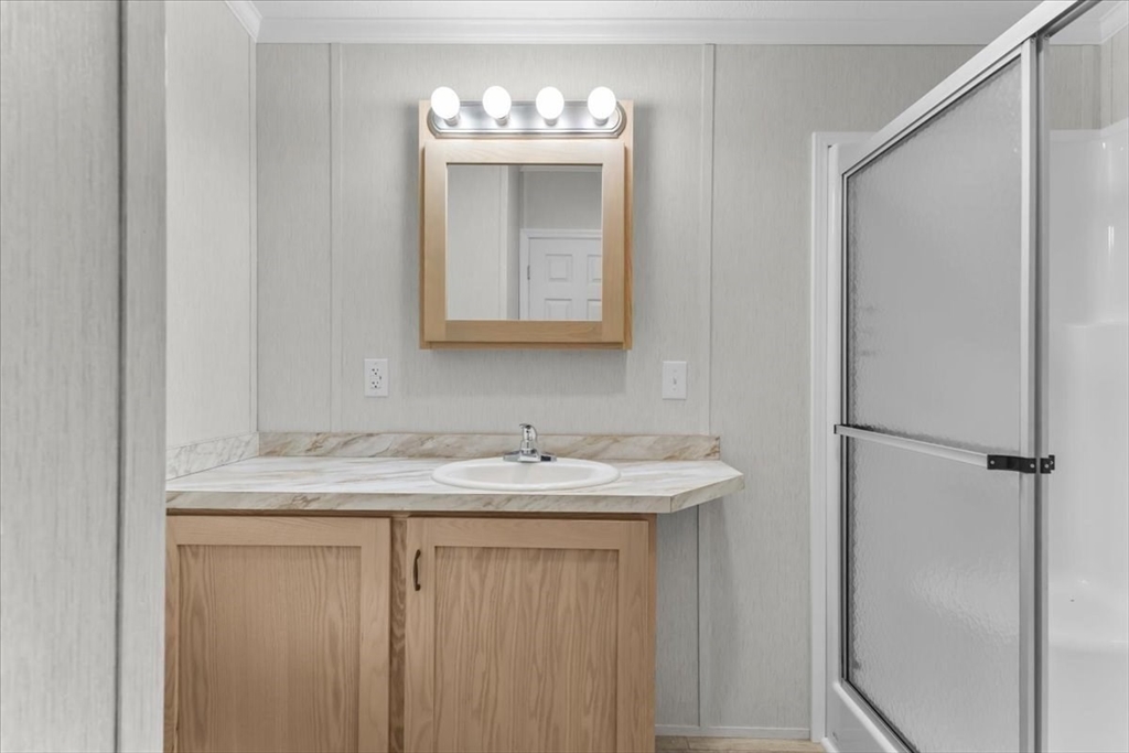 1540 Broadway, Unit 35 Raynham, MA 02767 - Photo 18 of 21 a bathroom with a granite countertop sink and a mirror