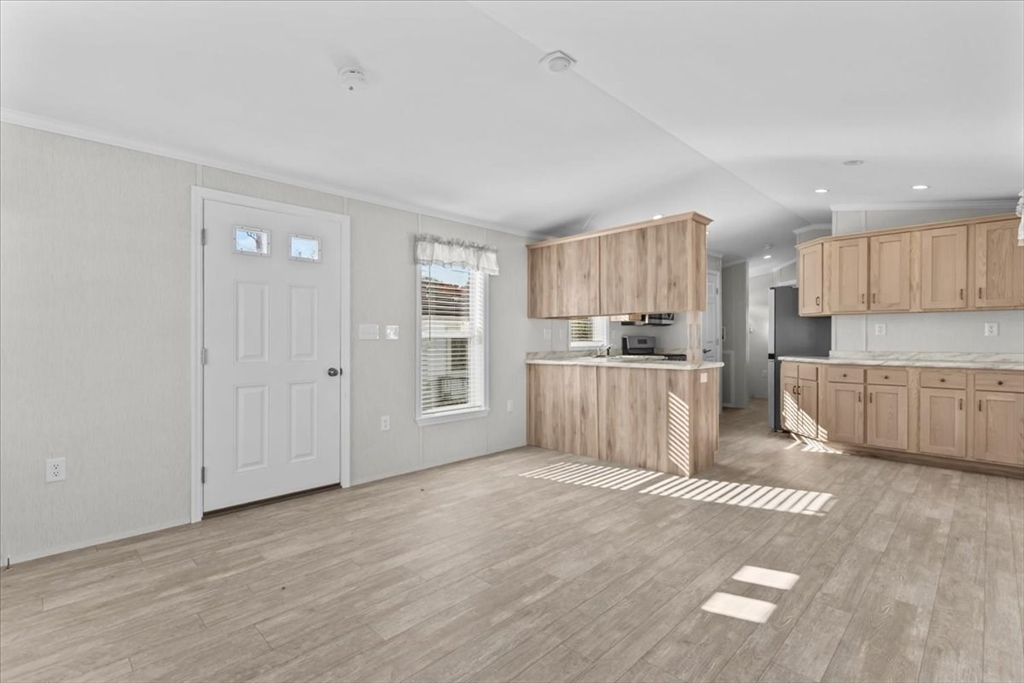 1540 Broadway, Unit 35 Raynham, MA 02767 - Photo 20 of 21 a kitchen with stainless steel appliances granite countertop a refrigerator sink and white cabinets