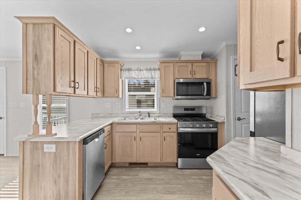 1540 Broadway, Unit 35 Raynham, MA 02767 - Photo 5 of 21 a kitchen with stainless steel appliances granite countertop a stove top oven a sink dishwasher and a refrigerator with wooden floor