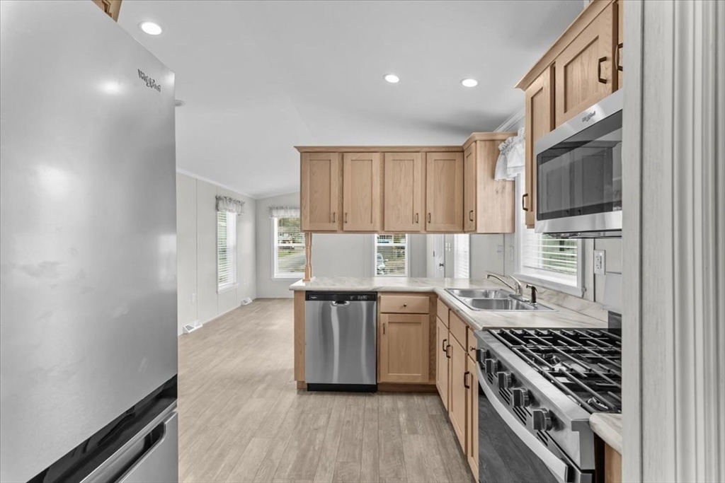 1540 Broadway, Unit 35 Raynham, MA 02767 - Photo 7 of 21 a kitchen with stainless steel appliances granite countertop a stove and a sink
