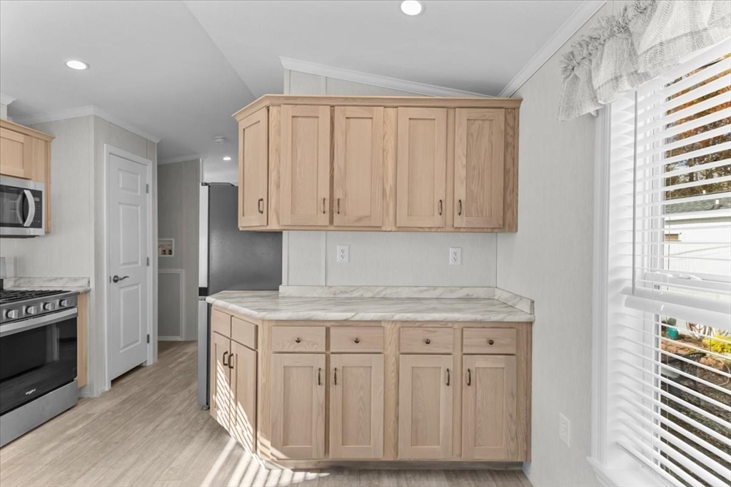 1540 Broadway, Unit 35 Raynham, MA 02767 - Photo 9 of 21 a kitchen with stainless steel appliances granite countertop a stove a sink and a white cabinets