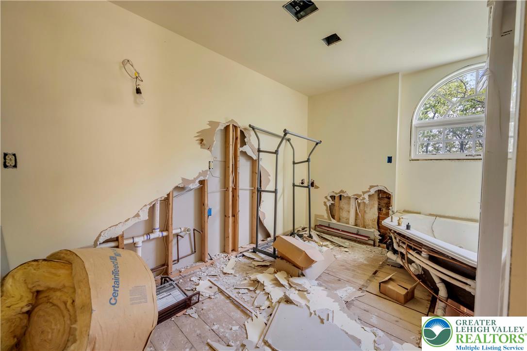 384 Henry Road Nazareth, PA 18064 - Photo 44 of 54 An arched window frames tree views in this bathroom space ready for custom renovation.