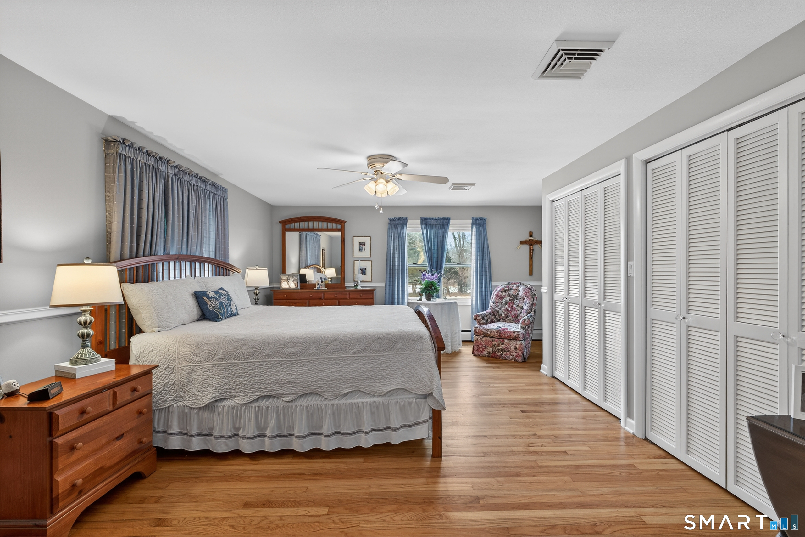 103 Maple Avenue Old Saybrook, CT 06475 - Photo 18 of 34 a spacious bedroom with a large bed and a chandelier