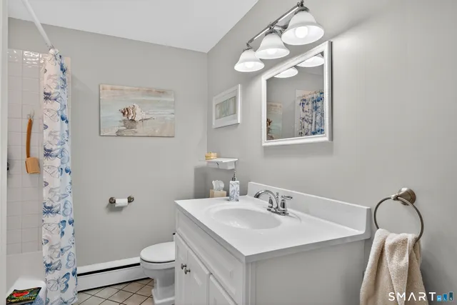 a bathroom with a sink vanity mirror and toilet