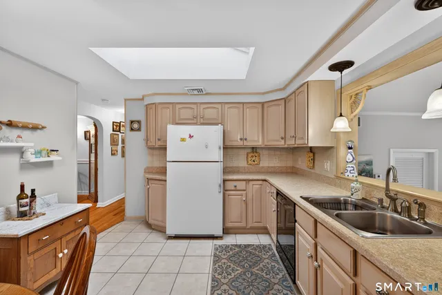 a kitchen with a sink a refrigerator and cabinets