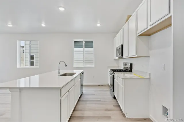 a kitchen with stainless steel appliances a sink stove and cabinets