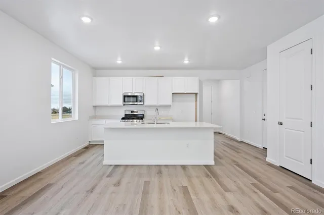 a view of kitchen with wooden floor and electronic appliances