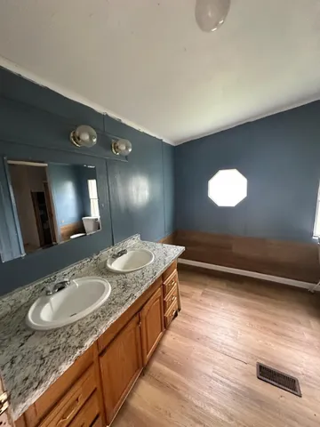 a bathroom with a granite countertop sink and a mirror