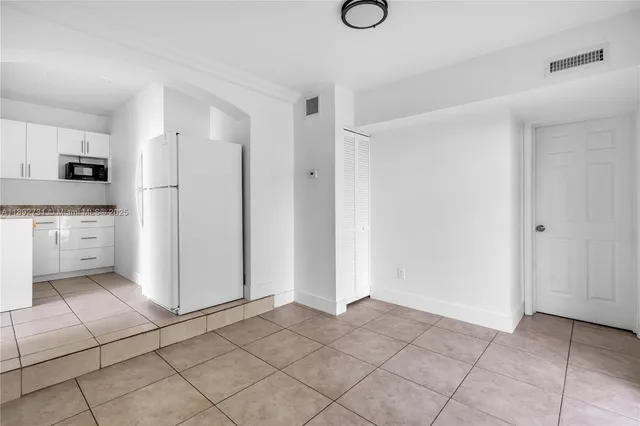 a view of a kitchen with a sink and a refrigerator cabinets