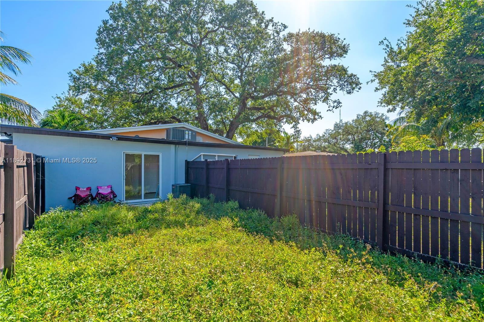 4111 Southwest 33rd Street, Unit B West Park, FL 33023 - Photo 6 of 8 a view of a backyard with potted plants and large trees