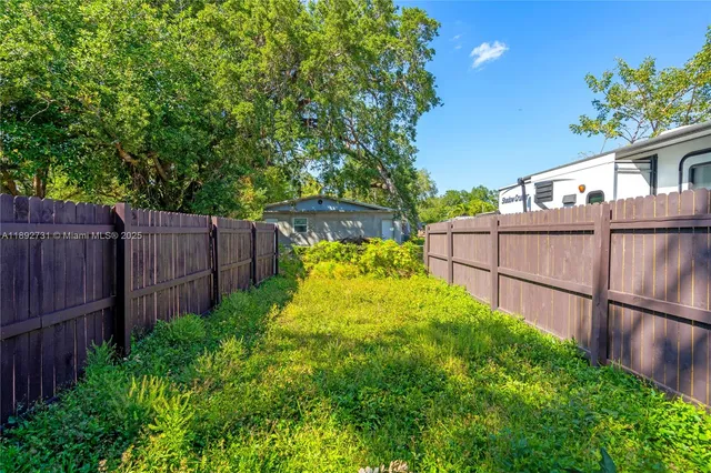 a view of a backyard with wooden fence