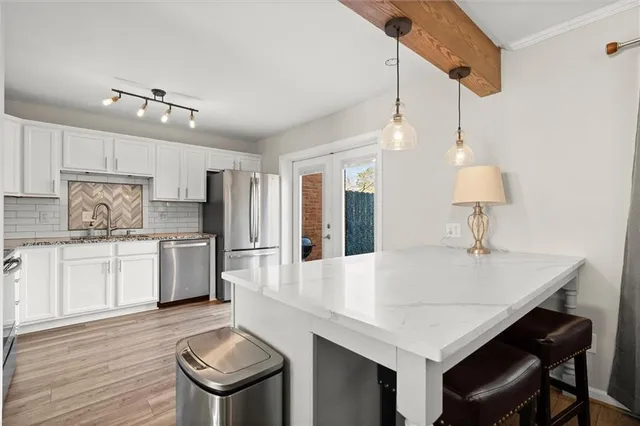 a kitchen with granite countertop a table chairs stove and refrigerator