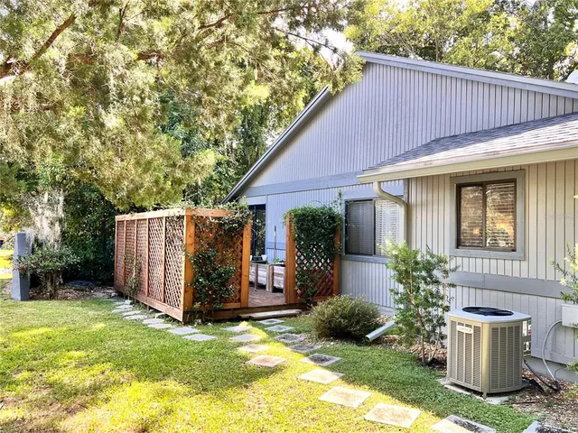a view of a yard with plants and trees