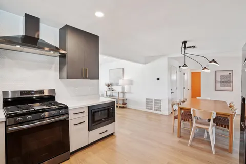 a kitchen with stainless steel appliances granite countertop a refrigerator and a stove top oven