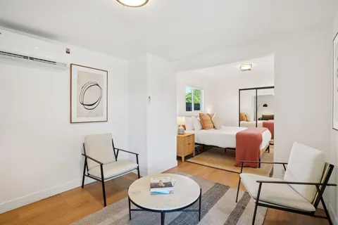 a living room with furniture and a wooden floor