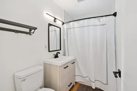 a bedroom with a bed and wooden floor