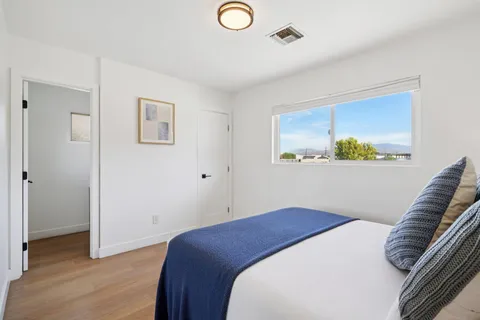 a bedroom with a bed and a painting on the wall