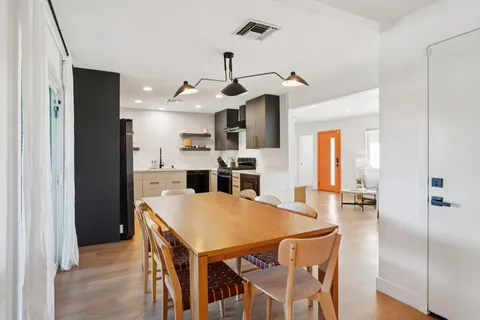 a kitchen with stainless steel appliances kitchen island granite countertop a stove and a wooden floors