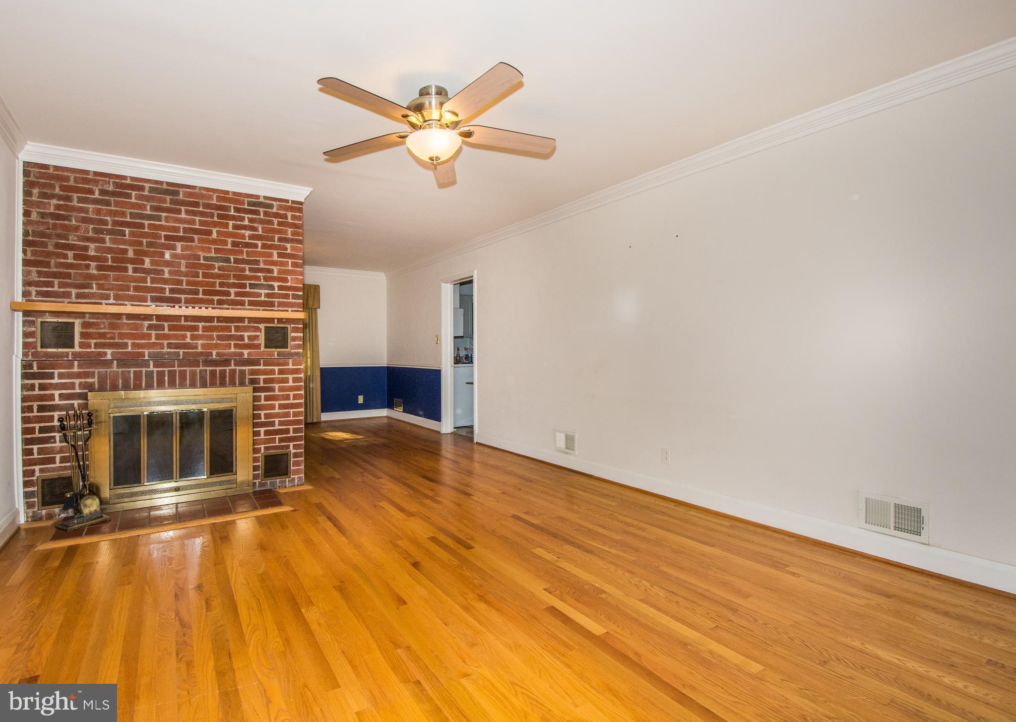 803 Quincy Road Baltimore, MD 21286 - Photo 4 of 28 a view of a livingroom with a fireplace a ceiling fan and wooden floor