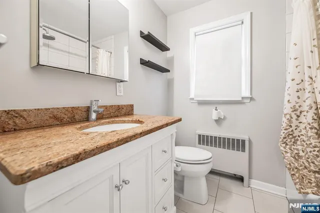 a bathroom with a granite countertop sink a toilet and a mirror