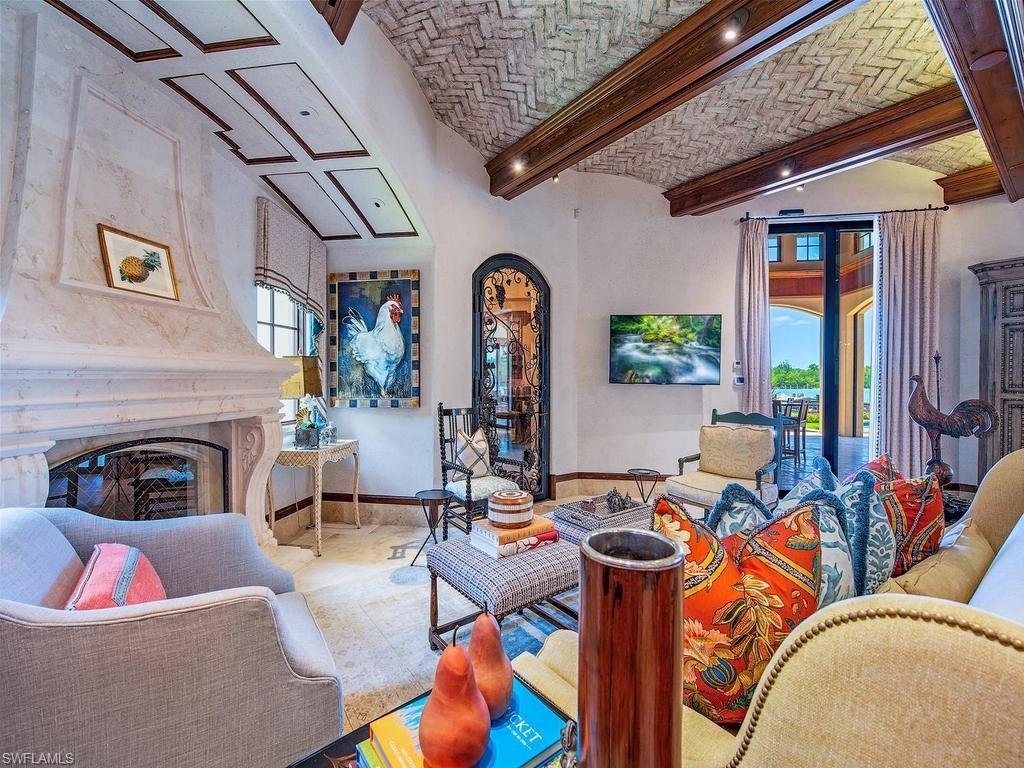 840 Admiralty Parade Naples, FL 34102 - Photo 28 of 50 a living room with furniture a rug and a fireplace