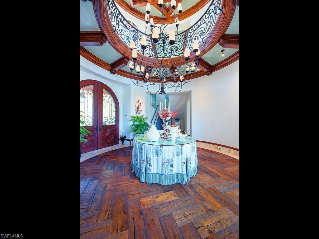 840 Admiralty Parade Naples, FL 34102 - Photo 36 of 50 a view of a dining room with a chandelier and wooden floor