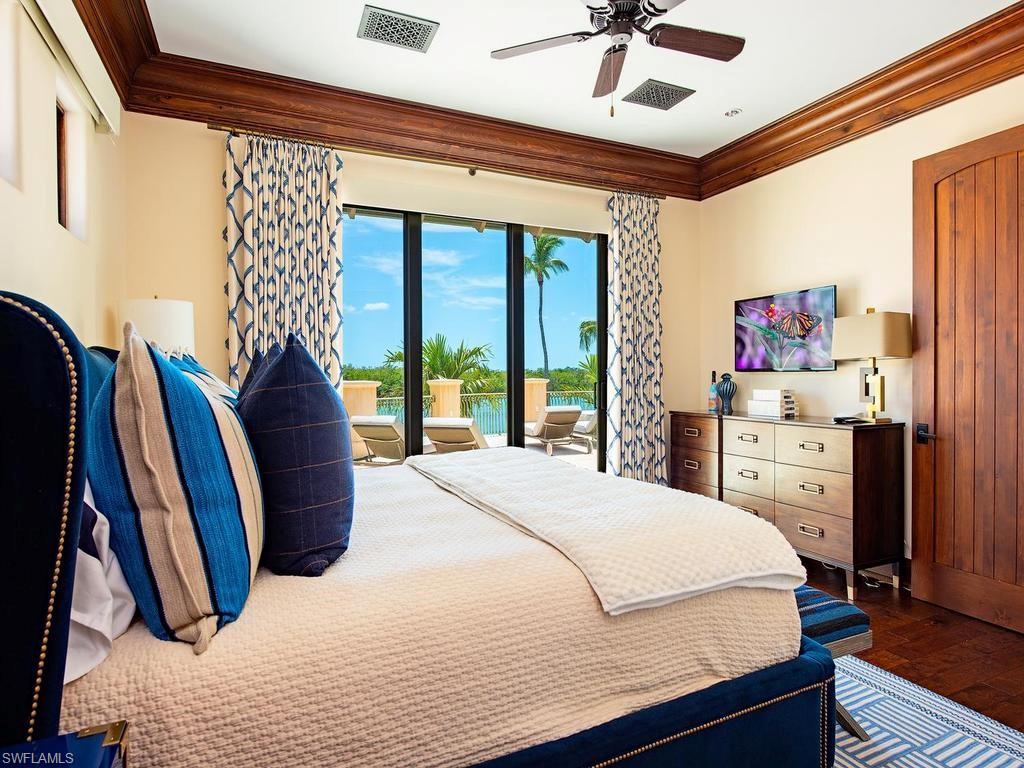 840 Admiralty Parade Naples, FL 34102 - Photo 40 of 50 a bedroom with a bed and a chandelier