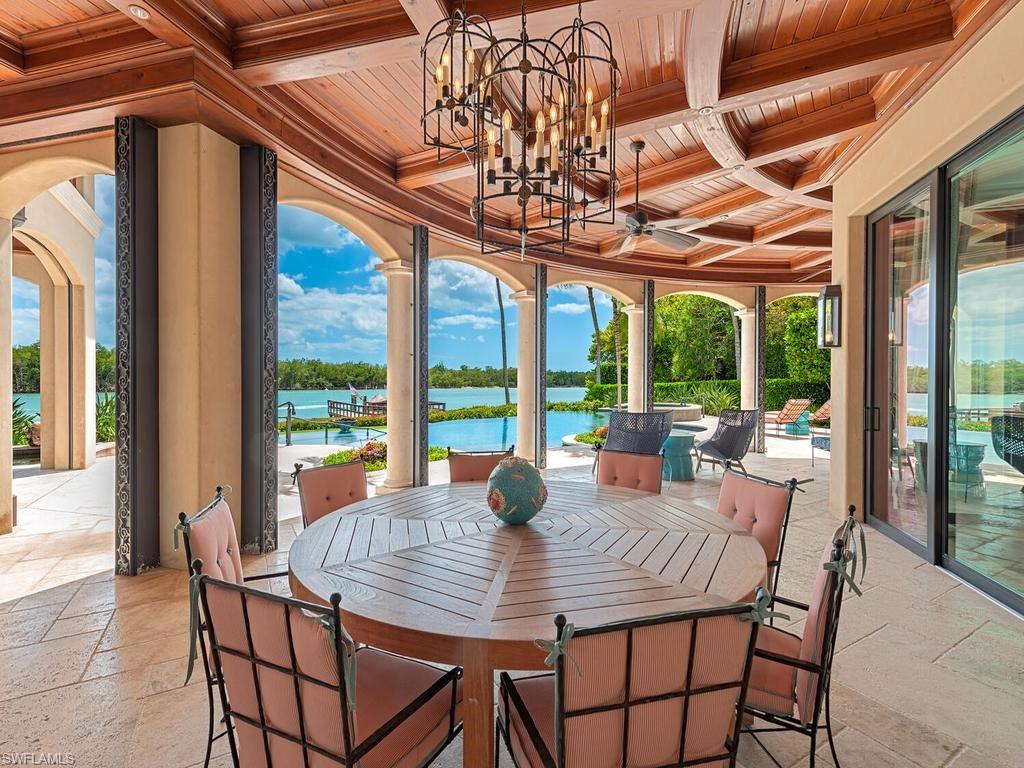 840 Admiralty Parade Naples, FL 34102 - Photo 4 of 50 a view of a dining room with furniture large windows and wooden floor