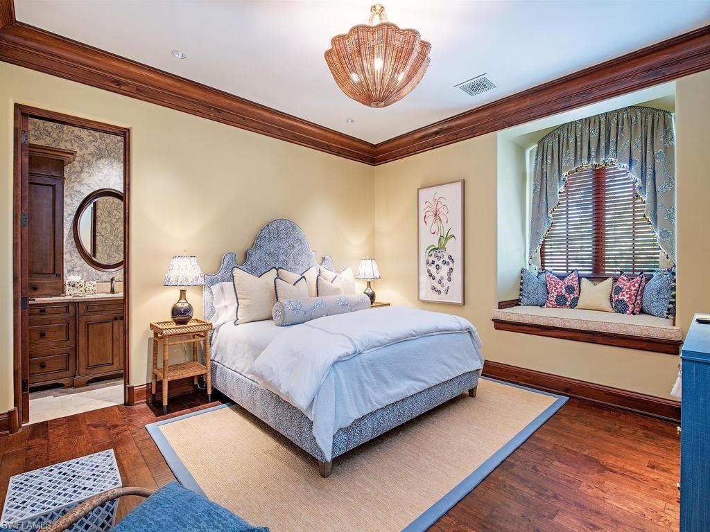 840 Admiralty Parade Naples, FL 34102 - Photo 41 of 50 a bedroom with a bed and dresser with mirror