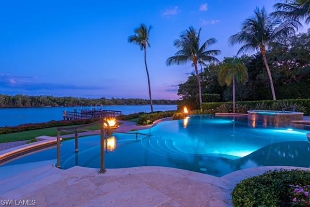840 Admiralty Parade Naples, FL 34102 - Photo 45 of 50 a view of a swimming pool with a table and chairs