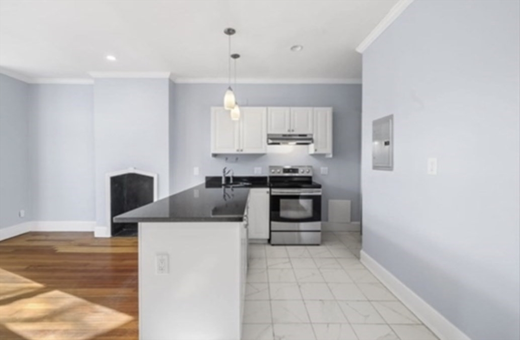 1834 Beacon Street, Unit 5 Brookline, MA 02445 - Photo 2 of 6 a kitchen with stainless steel appliances a stove microwave and cabinets