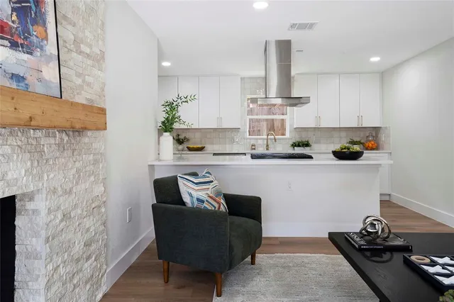 a kitchen with stainless steel appliances granite countertop a sink a stove and a wooden floors