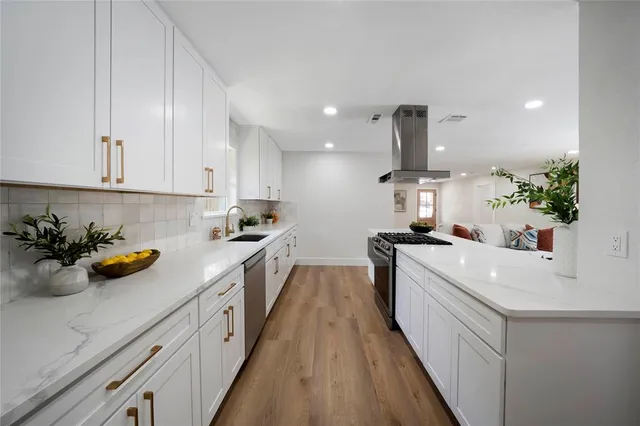 a kitchen with cabinets stainless steel appliances a sink a counter top space and cabinets