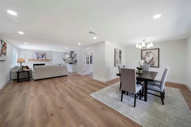 a living room with furniture and a dining table with wooden floor