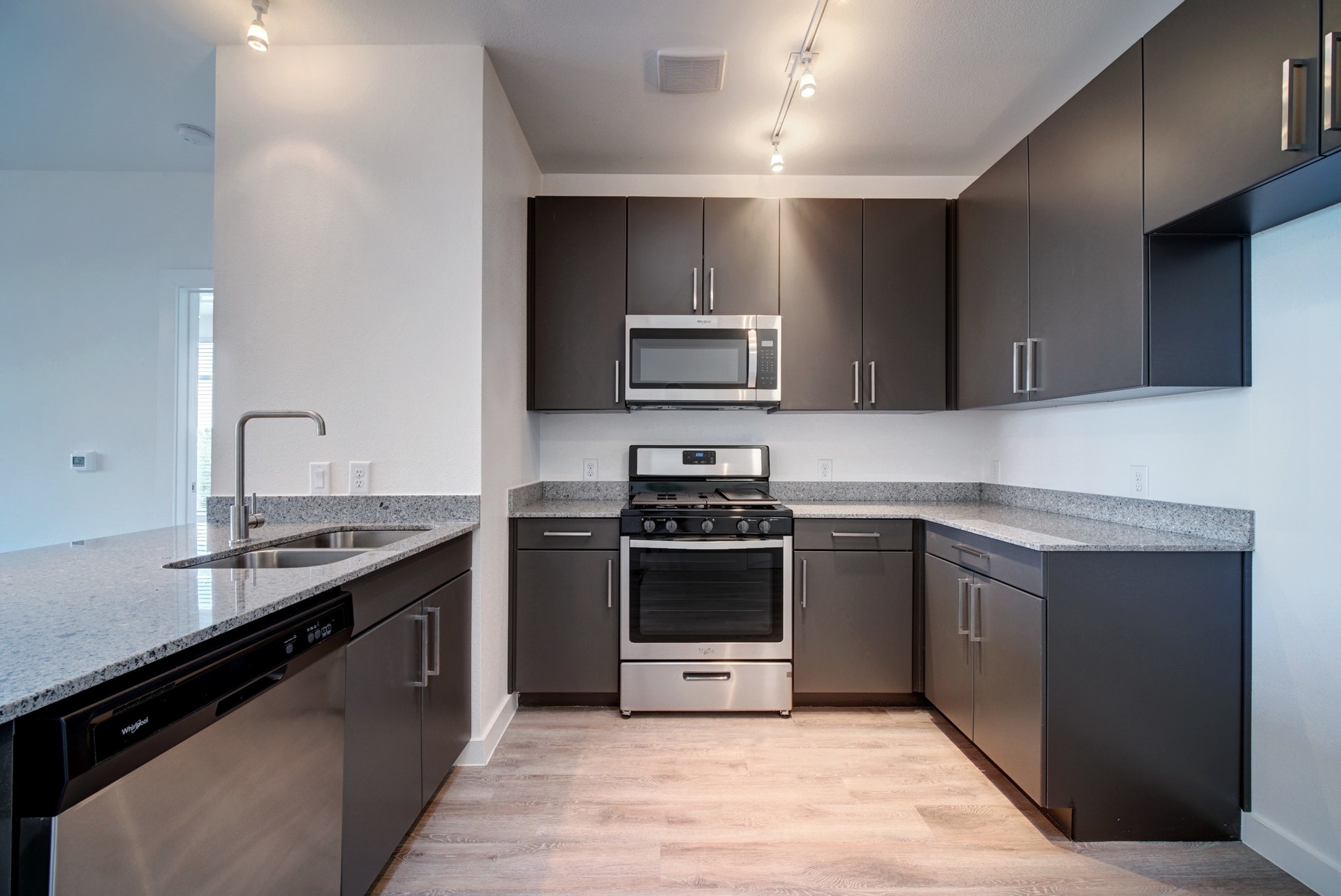 13130 Pond Springs Road, Unit 3214 Austin, TX 78729 - Photo 11 of 40 Kitchen with track lighting, stainless steel appliances, light stone countertops, and light wood-type flooring
