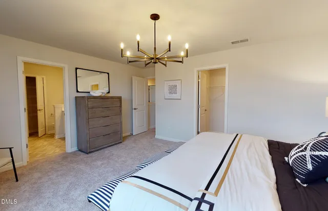 a bedroom with a bed and a chandelier