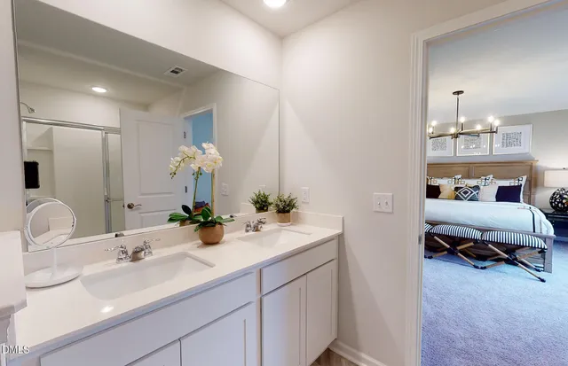 a en suite bathroom with double sink and a mirror