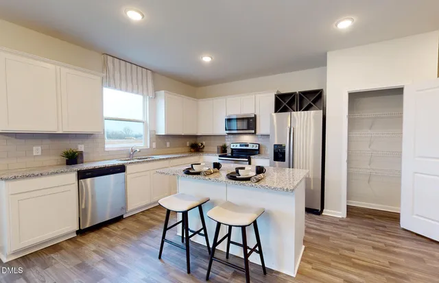 a kitchen with a sink a microwave a refrigerator and cabinets
