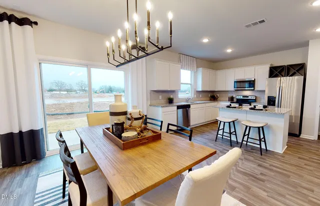 a kitchen with a dining table chairs refrigerator and cabinets