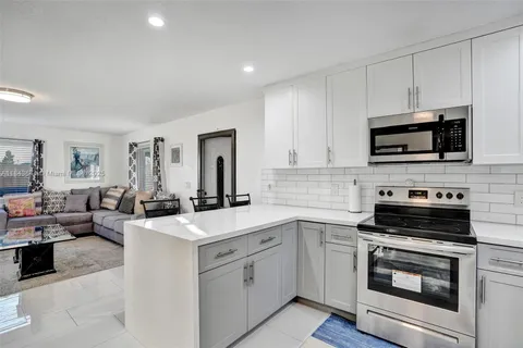a view of kitchen with sink stainless steel appliances and cabinets