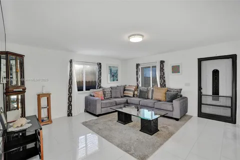 a living room with lots of furniture and a view of kitchen