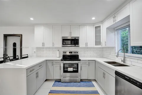 a kitchen with a sink stove and microwave