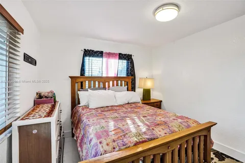 a bed sitting in a bedroom next to a window