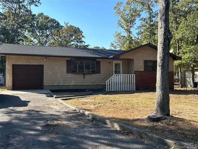a front view of a house with a yard covered with snow